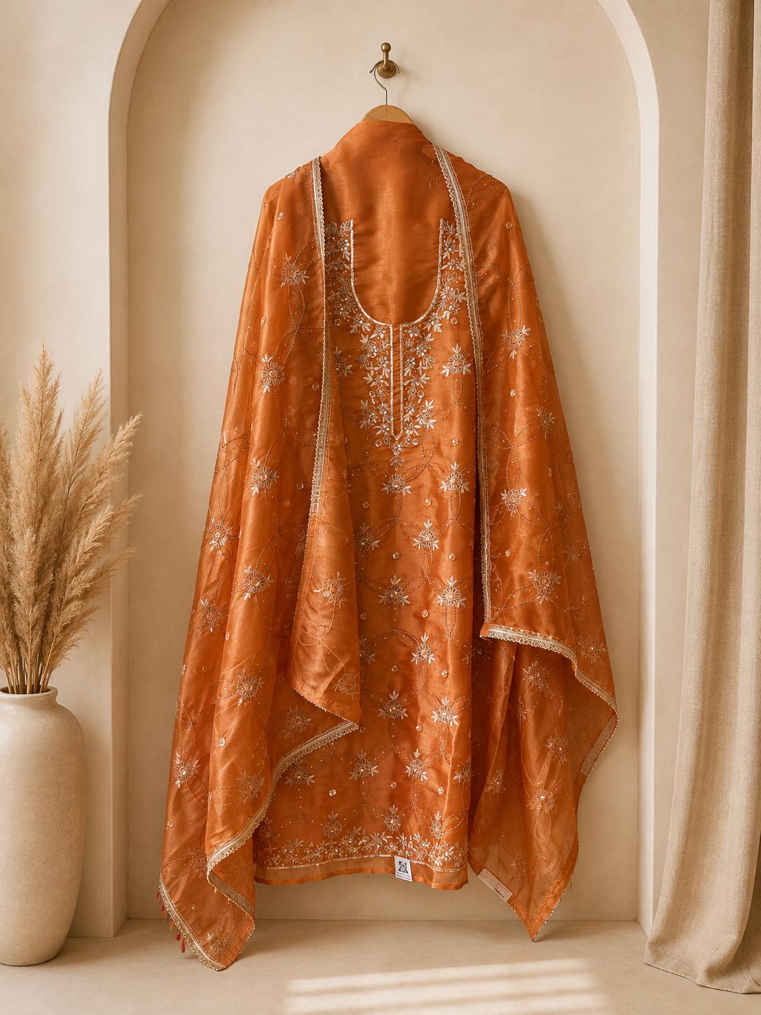 Luxurious unstitched orange festive suit crafted for sophisticated party wear
